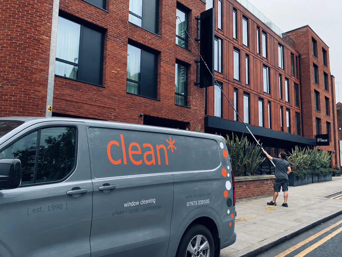 The clean* electric van and a window cleaner using a water-fed pole outside The Forge in Chester